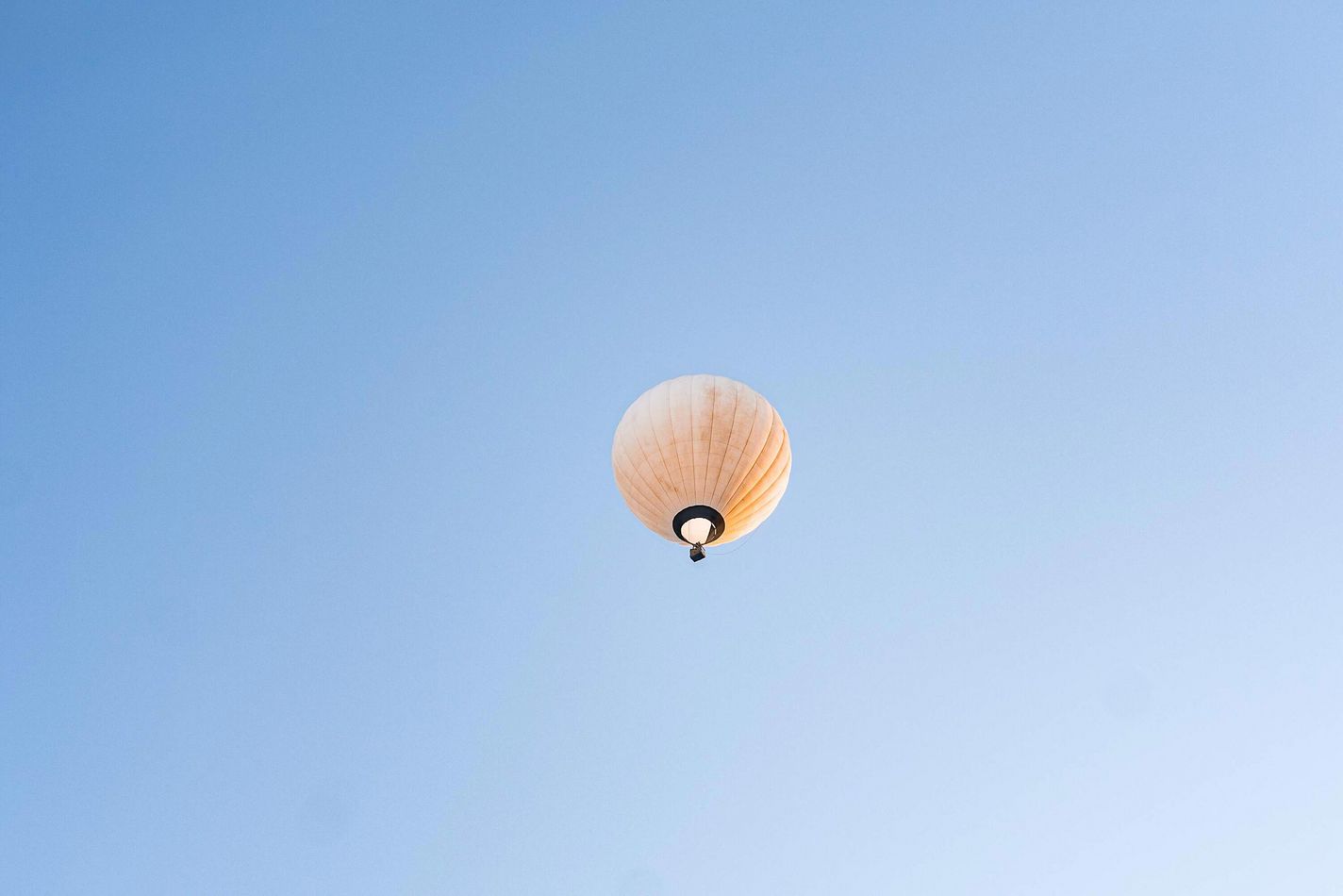 Gelber fliegender Heissluftballon steigt auf.