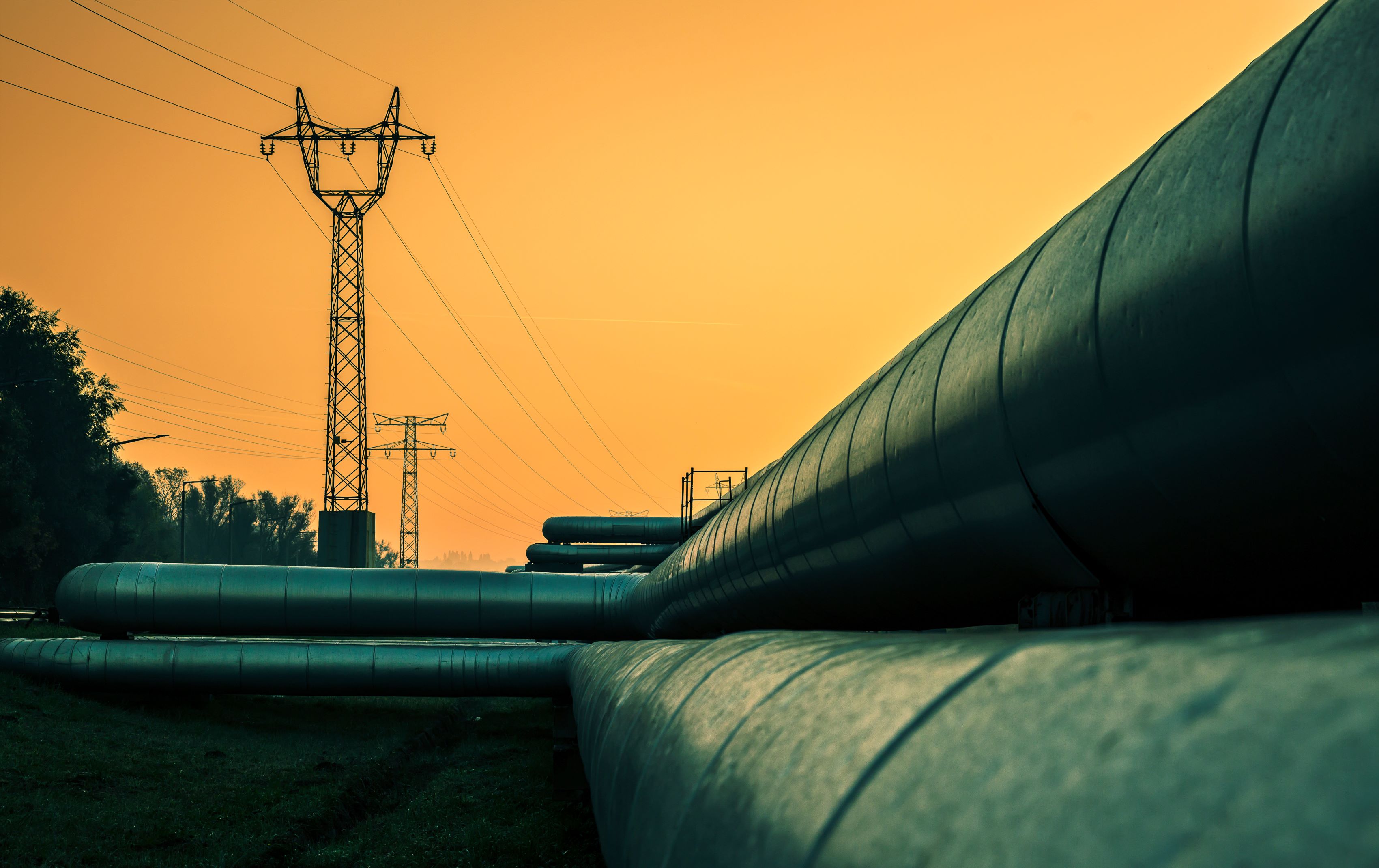 Photo: District heating pipes and electricity pylons at sunset